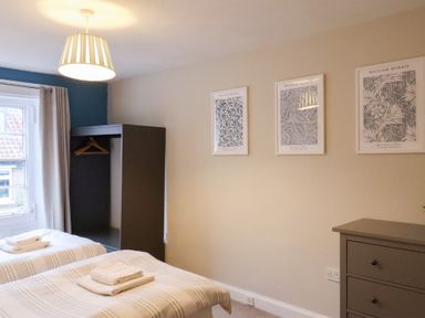 A bedroom with two beds and a wardrobe at The Lodge in Snainton near Scarborough