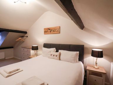 A bedroom with a bed and nightstands at The Lodge in Snainton near Scarborough