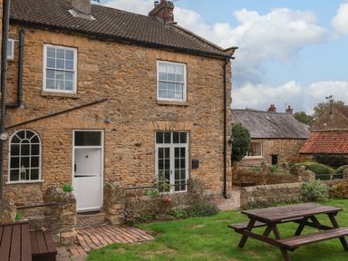 An outdoor view of a house with a garden at The Lodge in Snainton near Scarborough