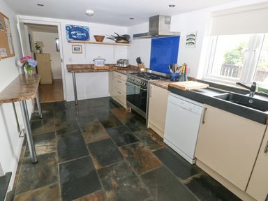 A kitchen with a stove dishwasher sink and countertop at Hillbrook House in Nolton Haven