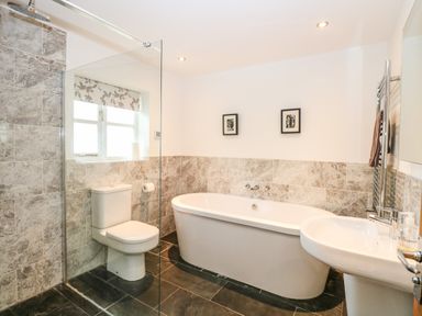 A bathroom with a toilet bathtub sink and a glass shower partition at Oak Tree Lodge in Crostwick near Norwich