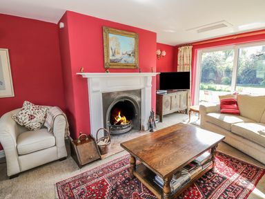 A living room with a fireplace armchairs a wooden coffee table and a television at Highcroft  Stratford-Upon-Avon