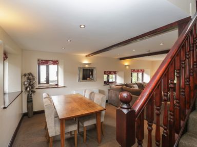 A living room with a dining table and chairs at Woodside Barn in Pennington near Ulverston