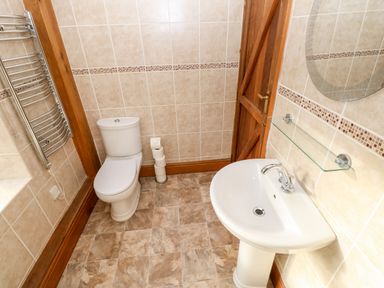 A bathroom with a toilet a sink a mirror and a towel rack at The Stable in Milton near Brampton