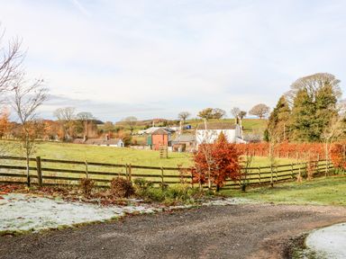 A rural landscape with gravel path fenced pastures and farm buildings at The Stable in Milton near Brampton