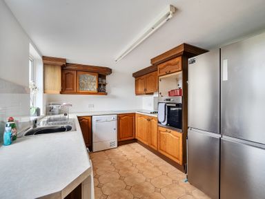 A kitchen with cabinets and appliances at Chapel Green in Polgooth