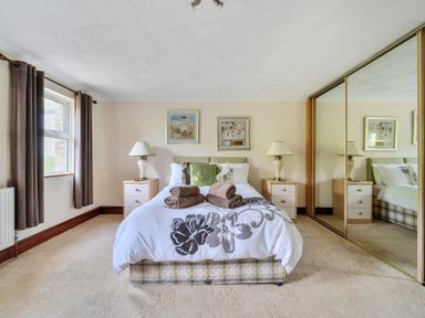 A bedroom with a bed and nightstands at Chapel Green, Polgooth