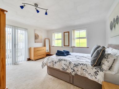A bedroom with a bed and dresser at Chapel Green in Polgooth