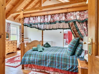 A bedroom featuring a four-poster bed and a dressing table at Chapel Green in Polgooth