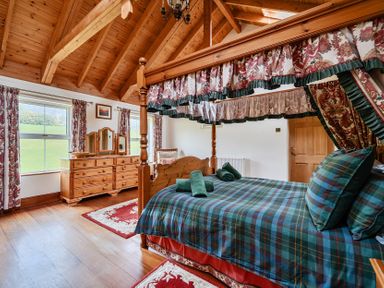 A bedroom with a four-poster bed and a dresser at Chapel Green in Polgooth