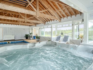 An indoor swimming pool area with a hot tub at Chapel Green in Polgooth
