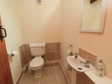 A bathroom with a toilet mirror and sink at Barn Cottage High Normanby near Robin Hood's Bay