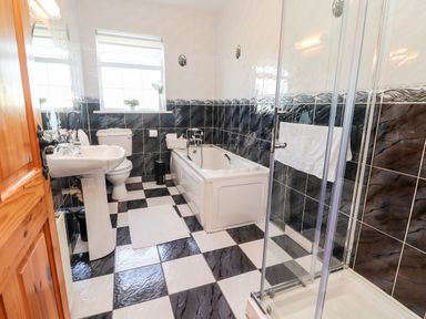 A bathroom with a bathtub shower enclosure toilet and sink at Fern View House in Beaufort near Killorglin County Kerry