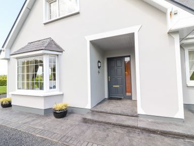 The exterior front door entrance area of a house with steps and two potted plants at Fern View House Beaufort near Killorglin County Kerry
