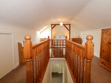A bedroom with a wooden railing and a bed at Brynteg in Llwyngwril