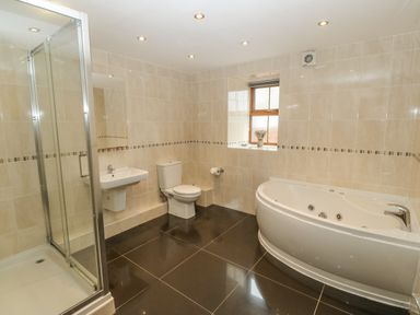 A bathroom with shower cubicle sink toilet corner bathtub and window at Cefn-Yr-Efail in Golan near Porthmadog