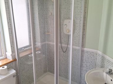 A shower enclosure with a toilet and sink at 19 River Glen in Curracloe, County Wexford