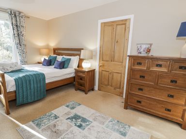 A bedroom with a bed and dresser at Tyddyn Goronwy in Talybont