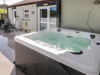 A hot tub with water in an outdoor area at Meadow View in Laugharne