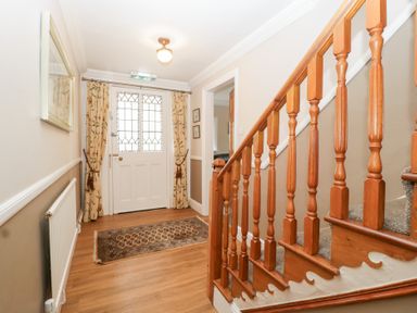 A hallway with a staircase and a front door at The Croft in Vowchurch near Peterchurch