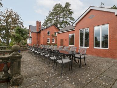 An outdoor patio with a large table and chairs at The Croft in Vowchurch near Peterchurch