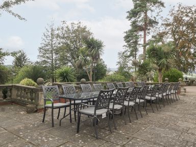 An outdoor dining area with a long table and chairs at The Croft in Vowchurch near Peterchurch