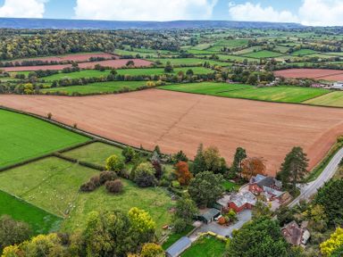 An aerial view of fields and a house with trees at The Croft in Vowchurch near Peterchurch