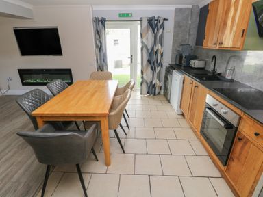 A kitchen with a dining table and modern appliances at Dylan's Court in Laugharne