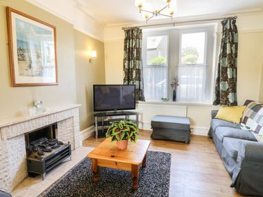 A living room with a fireplace television sofa coffee table and window at Riverside View in Cark in Cartmel