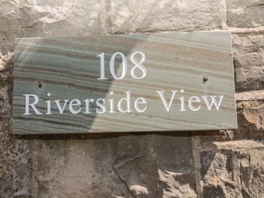 A stone sign with the number 108 and Riverside View on a stone wall at Riverside View in Cark in Cartmel