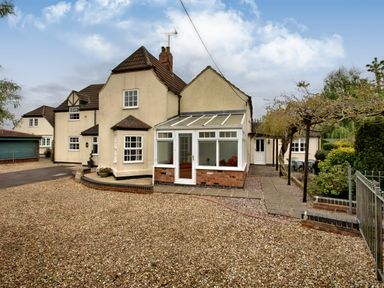 A house with a gravel driveway and a conservatory in the front at Ingleside in Adsett Royal Forest of Dean