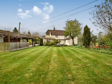 A garden with striped lawn trees and a house in the background at Ingleside Adsett Royal Forest of Dean