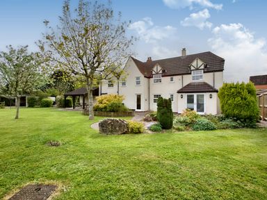 A large house with a tiled roof surrounded by a garden with trees bushes and a lawn at Ingleside in Adsett Royal Forest of Dean