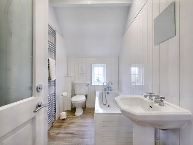A bathroom with a toilet bathtub sink a towel rack and a small window at Ingleside in Adsett Royal Forest of Dean