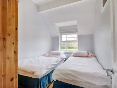A bedroom with two single beds and a window with a view of greenery at Ingleside in Adsett Royal Forest of Dean