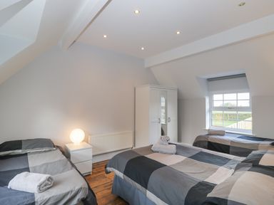 A bedroom with three single beds a white wardrobe and a nightstand with a lamp at Ingleside Adsett Royal Forest of Dean