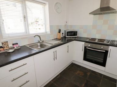 A kitchen with a sink a microwave an oven and cabinets at The Duck House in Wolfscastle