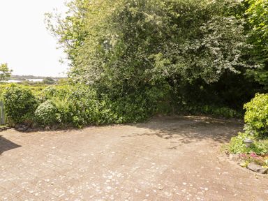 A paved outdoor area with bushes and trees surrounding it at The Duck House in Wolfscastle