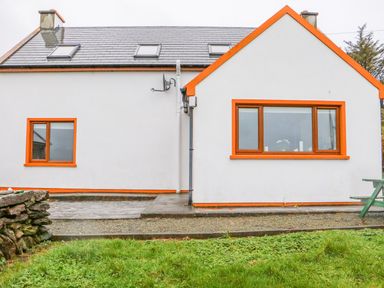 A white house with orange window frames and a gray roof with skylights at Mary Agnes Cottage in Cahirkeen near Allihies County Cork