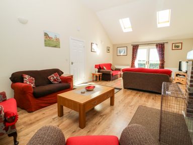 A living room with sofas and a wooden coffee table under skylights at 2 Pines Farm Cottages in Ulleskelf