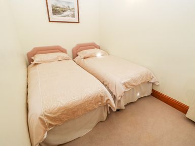 A small bedroom with two single beds and a framed picture on the wall at The Dairy in Milton near Brampton