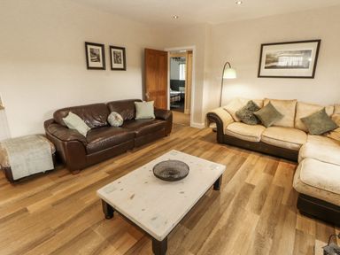 A living room with a brown sofa and coffee table at White Gables Great Clifton near Cockermouth