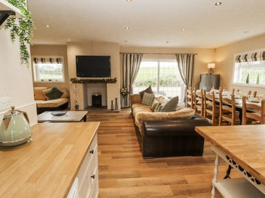 A living room with sofa and dining table at White Gables in Great Clifton near Cockermouth