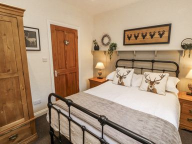 A bedroom with a bed and wardrobe at White Gables in Great Clifton near Cockermouth
