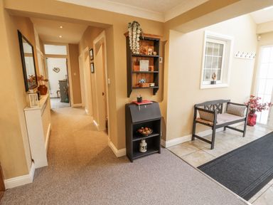 A hallway with a bench and shelf at White Gables in Great Clifton near Cockermouth