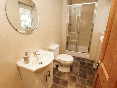 A bathroom with a sink, toilet, and shower at White Gables in Great Clifton near Cockermouth