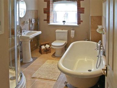 A bathroom with a pedestal sink toilet bathtub shower and window with a flower pot at Candy Cottage Thornford near Sherborne
