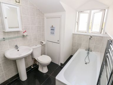 A bathroom with a pedestal sink toilet bathtub and a window at Saddlers Cottage Berllandeg Farm Clunderwen near Narberth