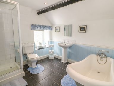 A bathroom with a toilet shower sink bathtub and window at Ty Fferm Bodlasan Llanfachraeth near Valley
