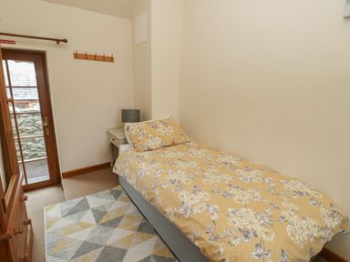 A bedroom with a bed and bedside table at Daffodil Cottage Caeathro near Caernarfon